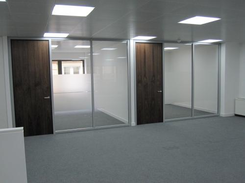 Glass partition system with walnut veneered doors